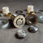 Patent-pending LV-RV stainless steel hose fitting for hot tubs and ice baths — complete component set with sealing gasket, clamping nut, washers, and closure caps
